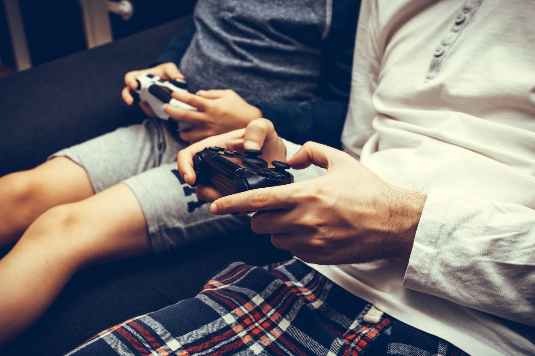 Close-up of parent and child playing video games.